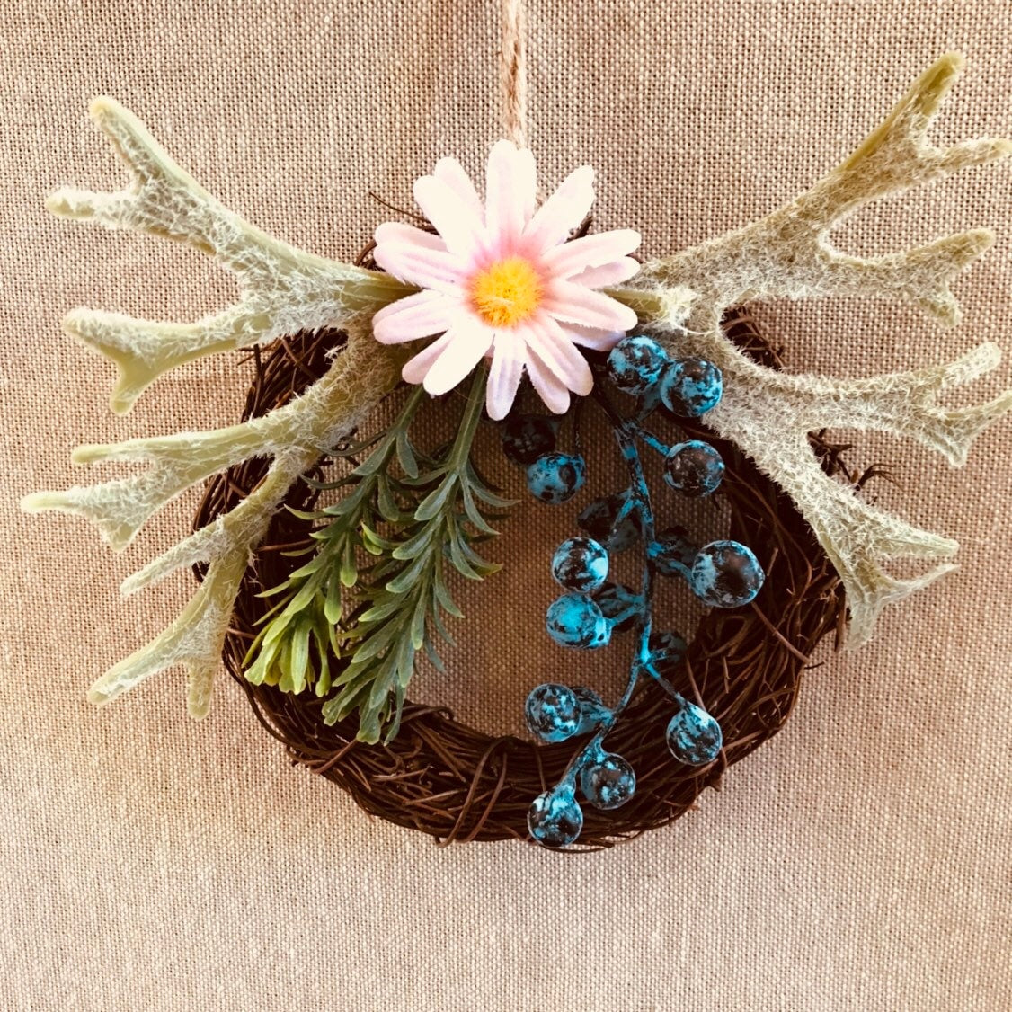 Mini floral wreath ornament with artificial flowers, ideal as a fairy door accessory or mini decor.