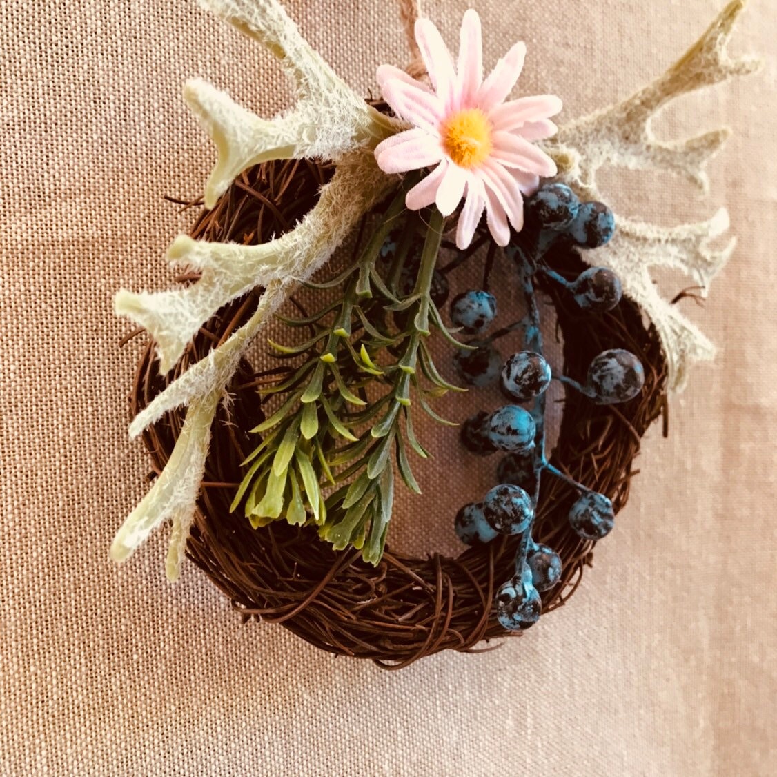 Mini floral wreath ornament with artificial flowers, ideal as a fairy door accessory or mini decor.