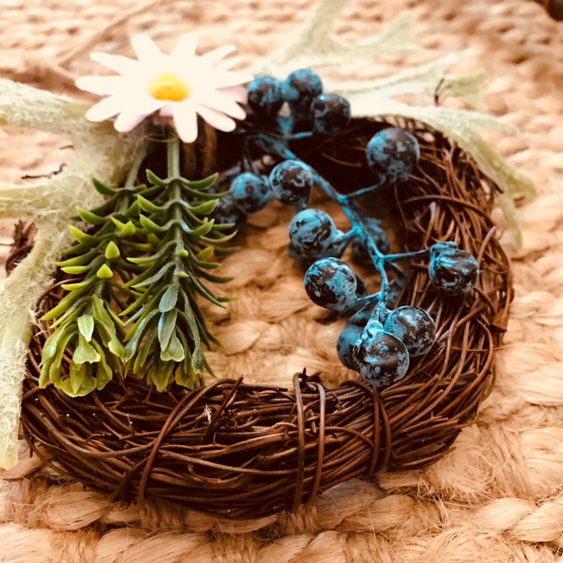 Mini floral wreath ornament with artificial flowers, ideal as a fairy door accessory or mini decor.