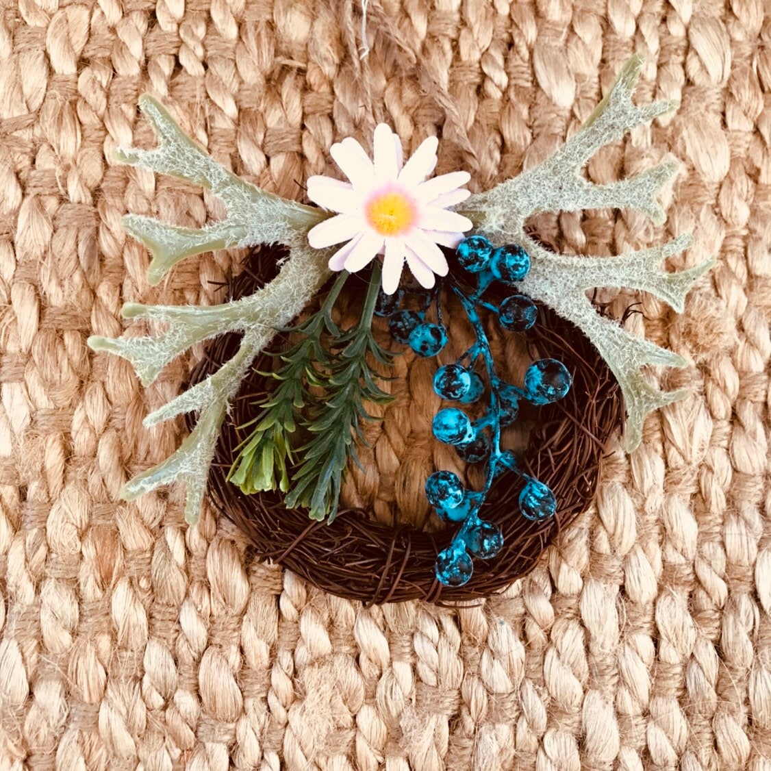 Mini floral wreath ornament with artificial flowers, ideal as a fairy door accessory or mini decor.
