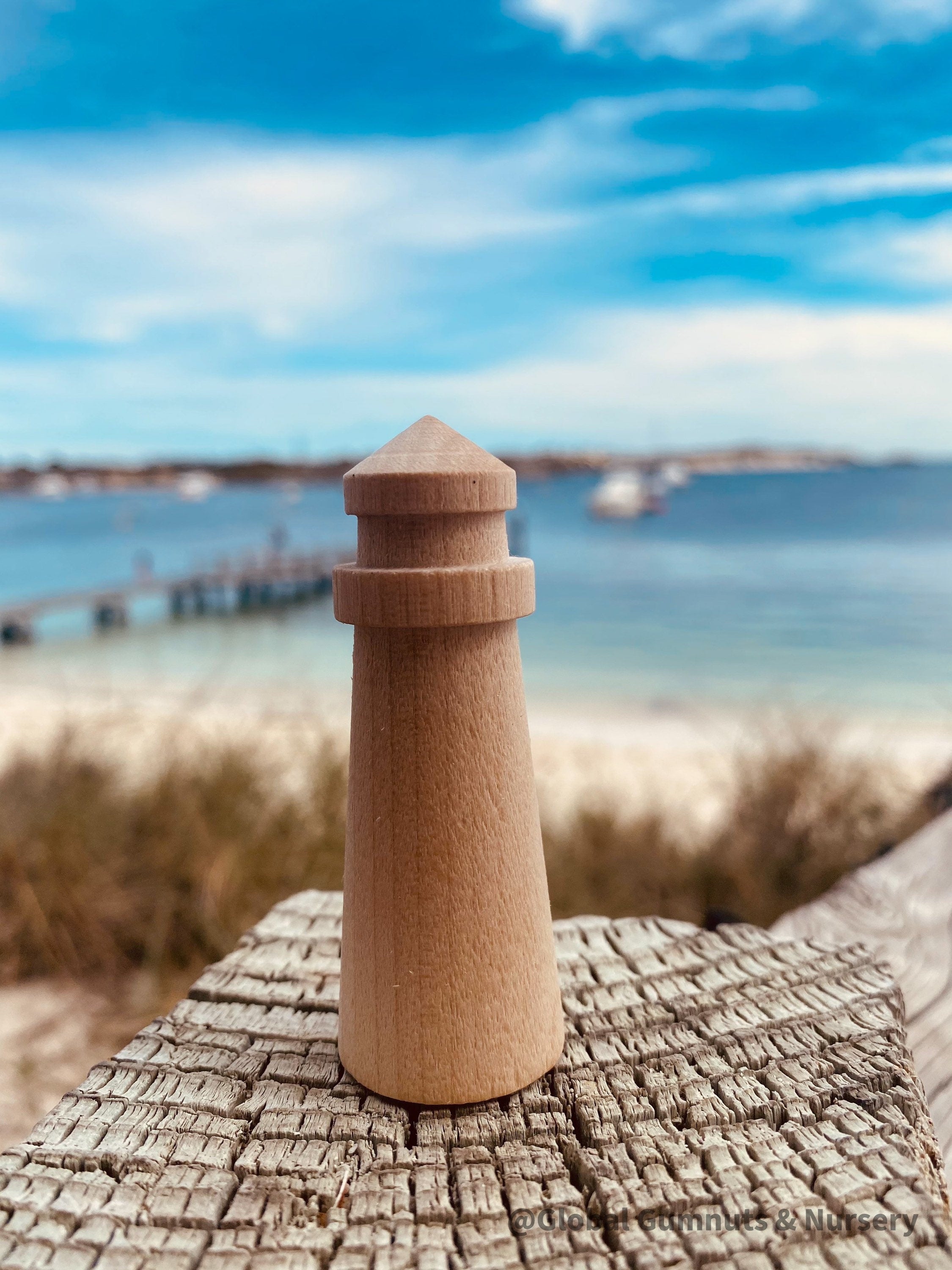 Mini wooden lighthouse, a charming addition to beach-themed decor or playtime.