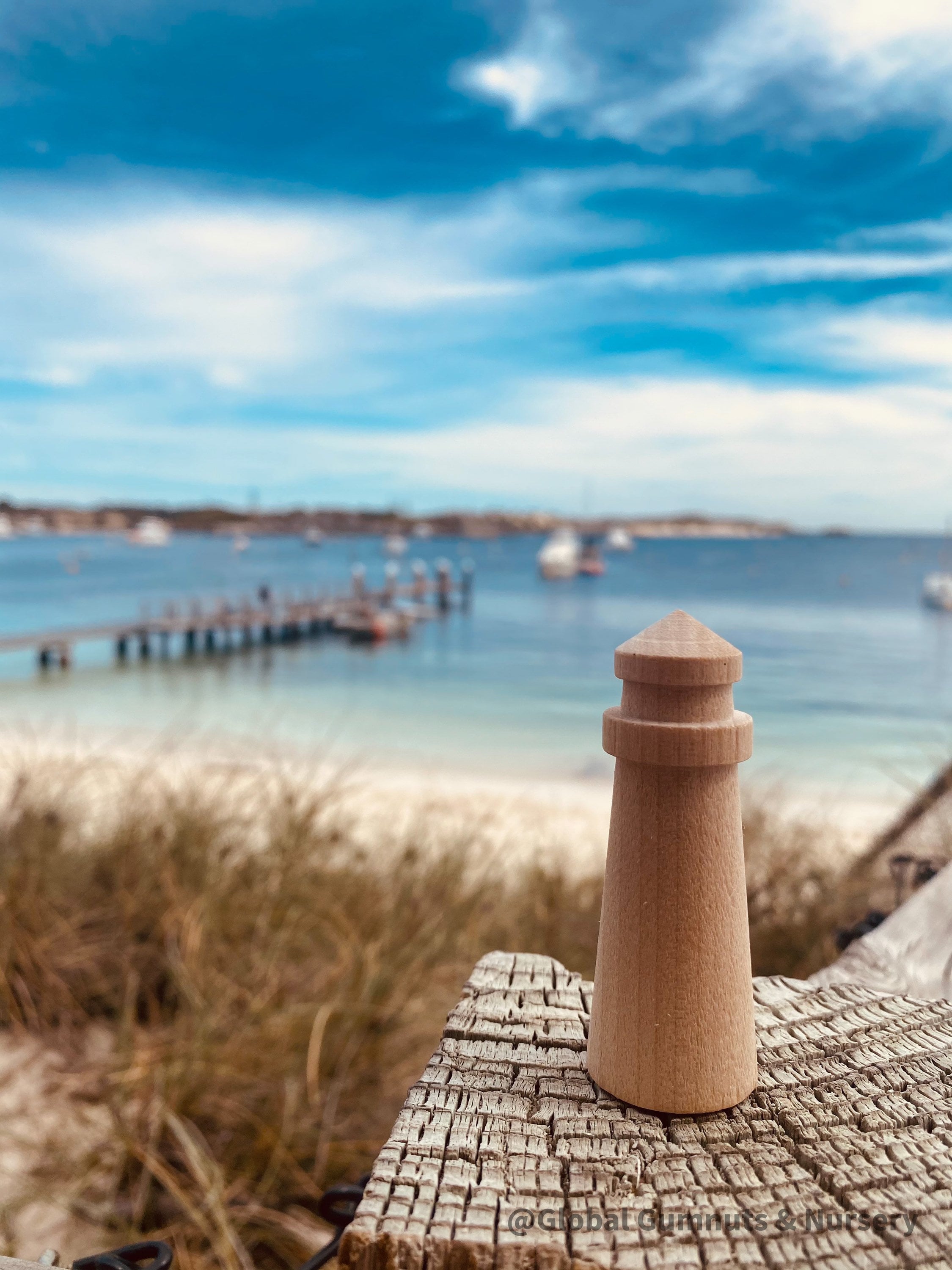 Mini wooden lighthouse, a charming addition to beach-themed decor or playtime.