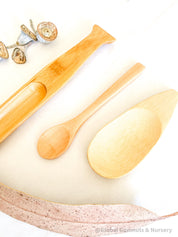 Flat rounded wooden scooper, a child-sized tool for small-world play or natural exploration.