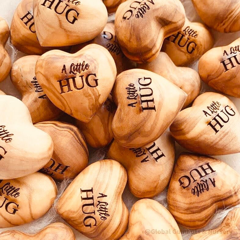 Gift a wooden heart engraved with love, a pocket-sized token of affection perfect for sending "a little hug."