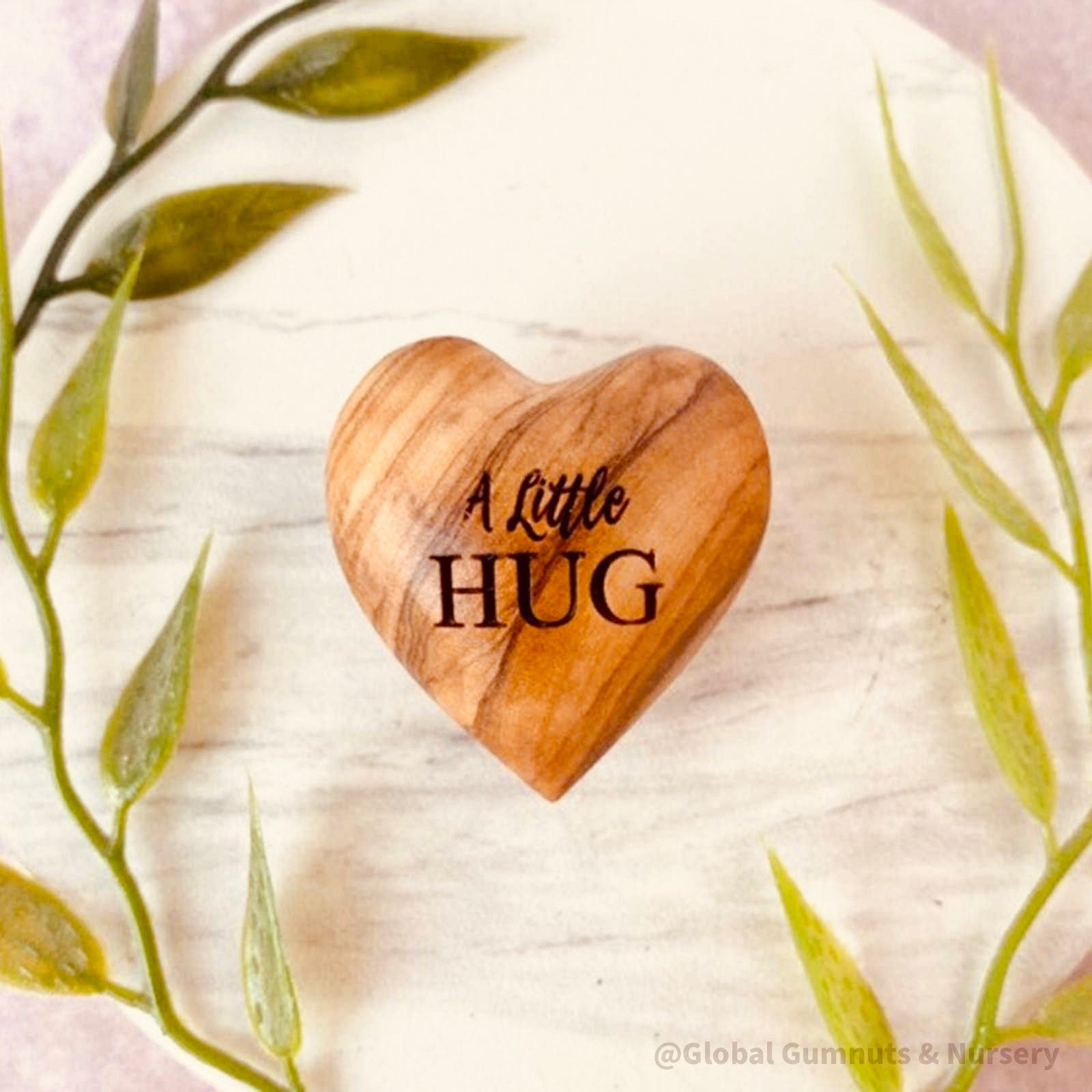 Gift a wooden heart engraved with love, a pocket-sized token of affection perfect for sending "a little hug."