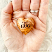 Gift a wooden heart engraved with love, a pocket-sized token of affection perfect for sending "a little hug."