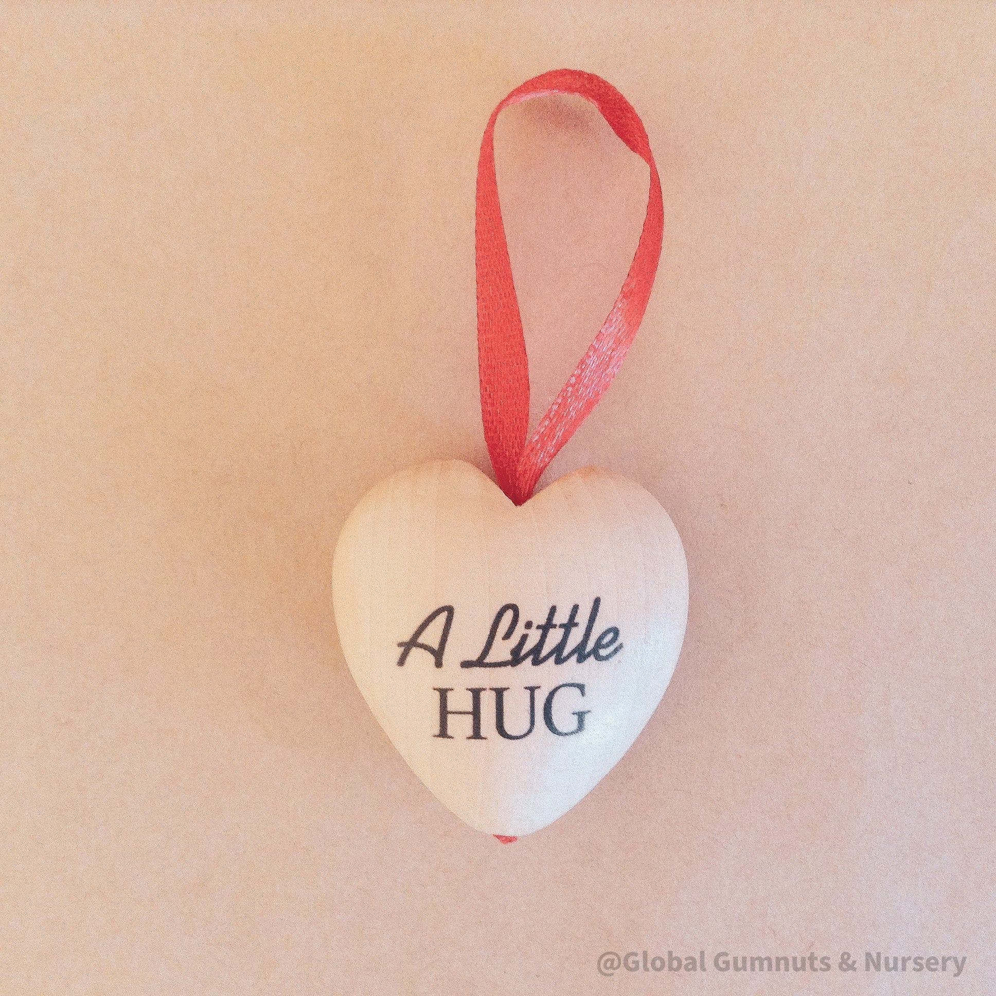 Gift a wooden heart engraved with love, a pocket-sized token of affection perfect for sending "a little hug."