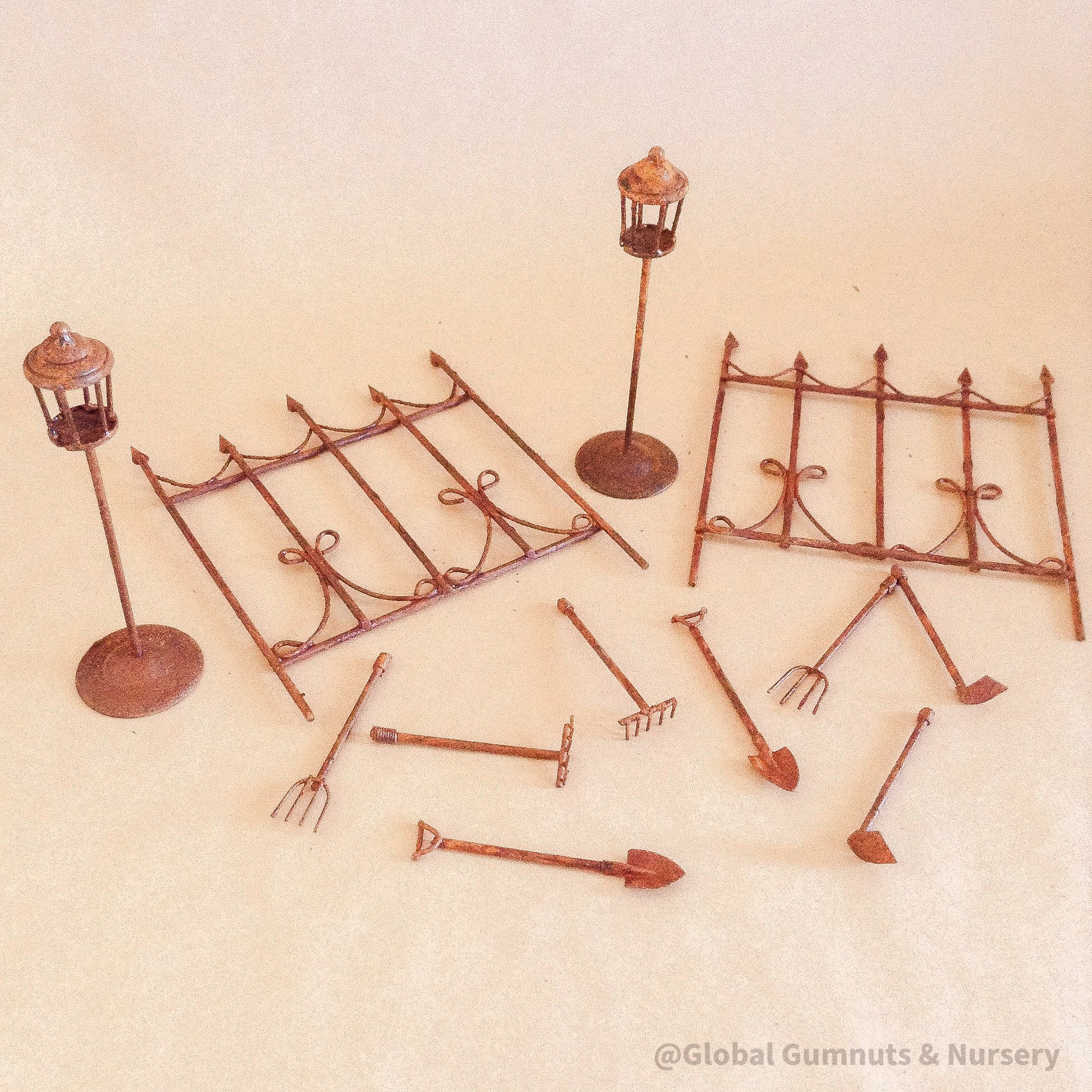Miniature fairy garden accessories set with fencing, tools, and lamp posts for magical play.
