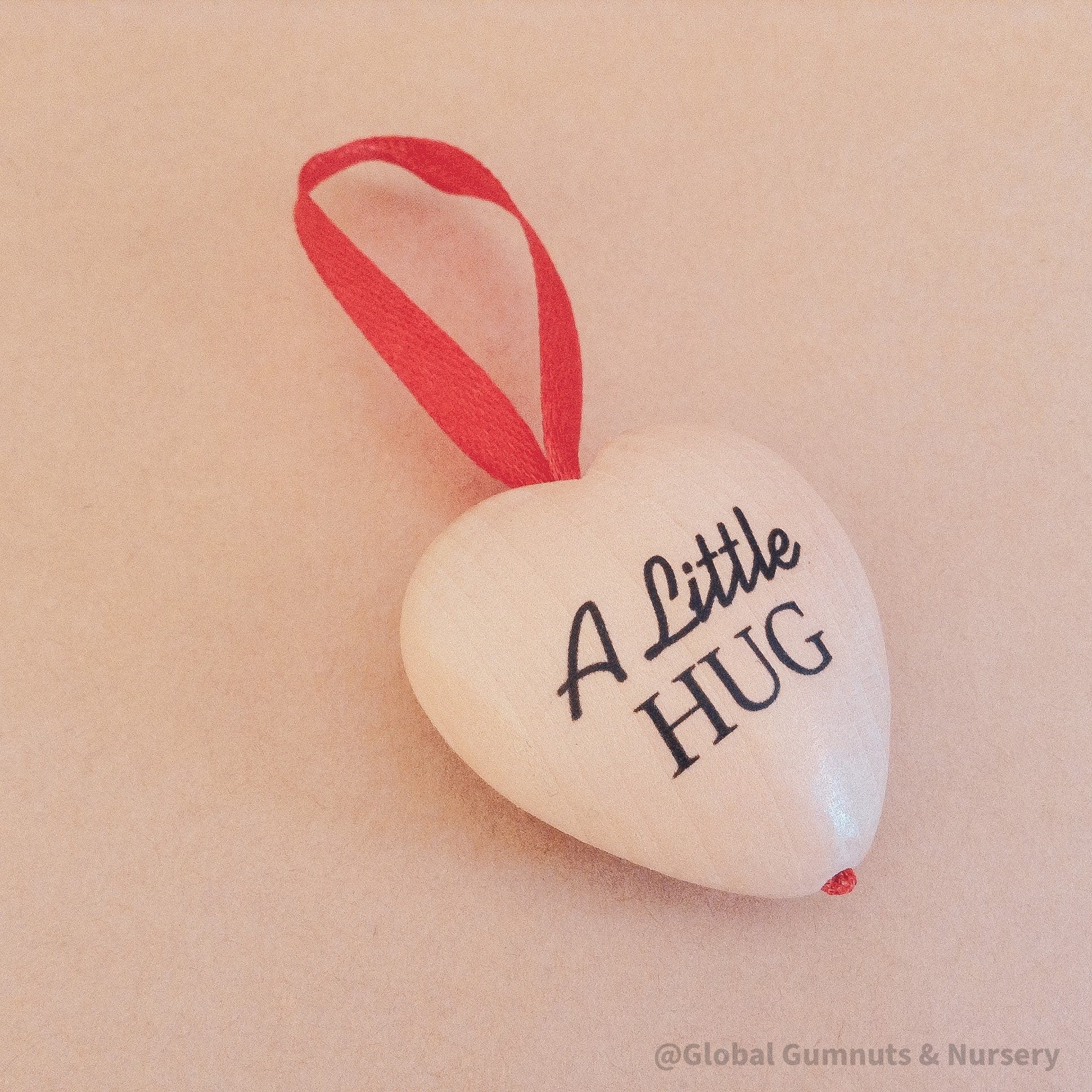 Gift a wooden heart engraved with love, a pocket-sized token of affection perfect for sending "a little hug."