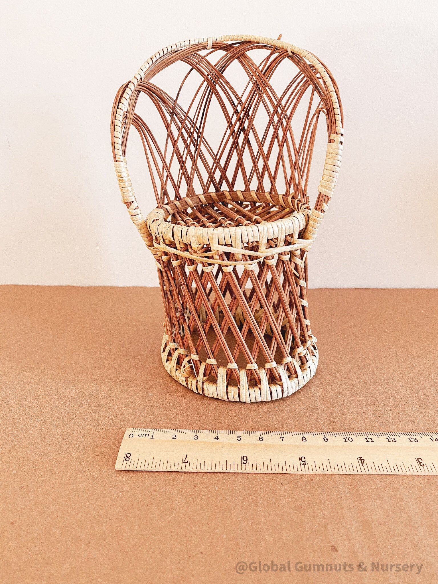 Vintage wicker doll's chair, measuring 20cm x 10cm.