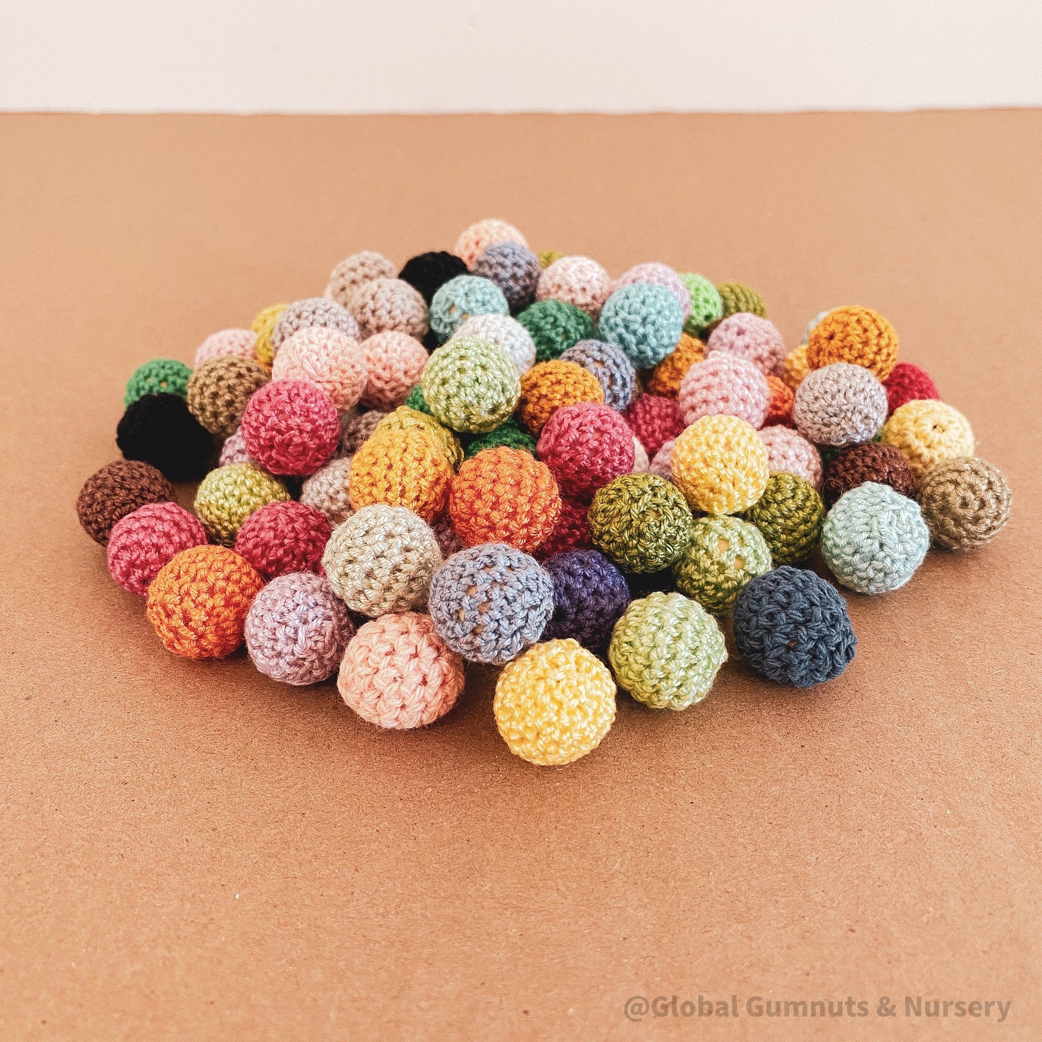 Crochet beaded wooden balls in warm or cool tones, perfect for sensory play, jewelry-making, or decor.