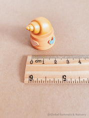 Miniature orange ocean shell on a stand, perfect for underwater-themed adventures or decor.