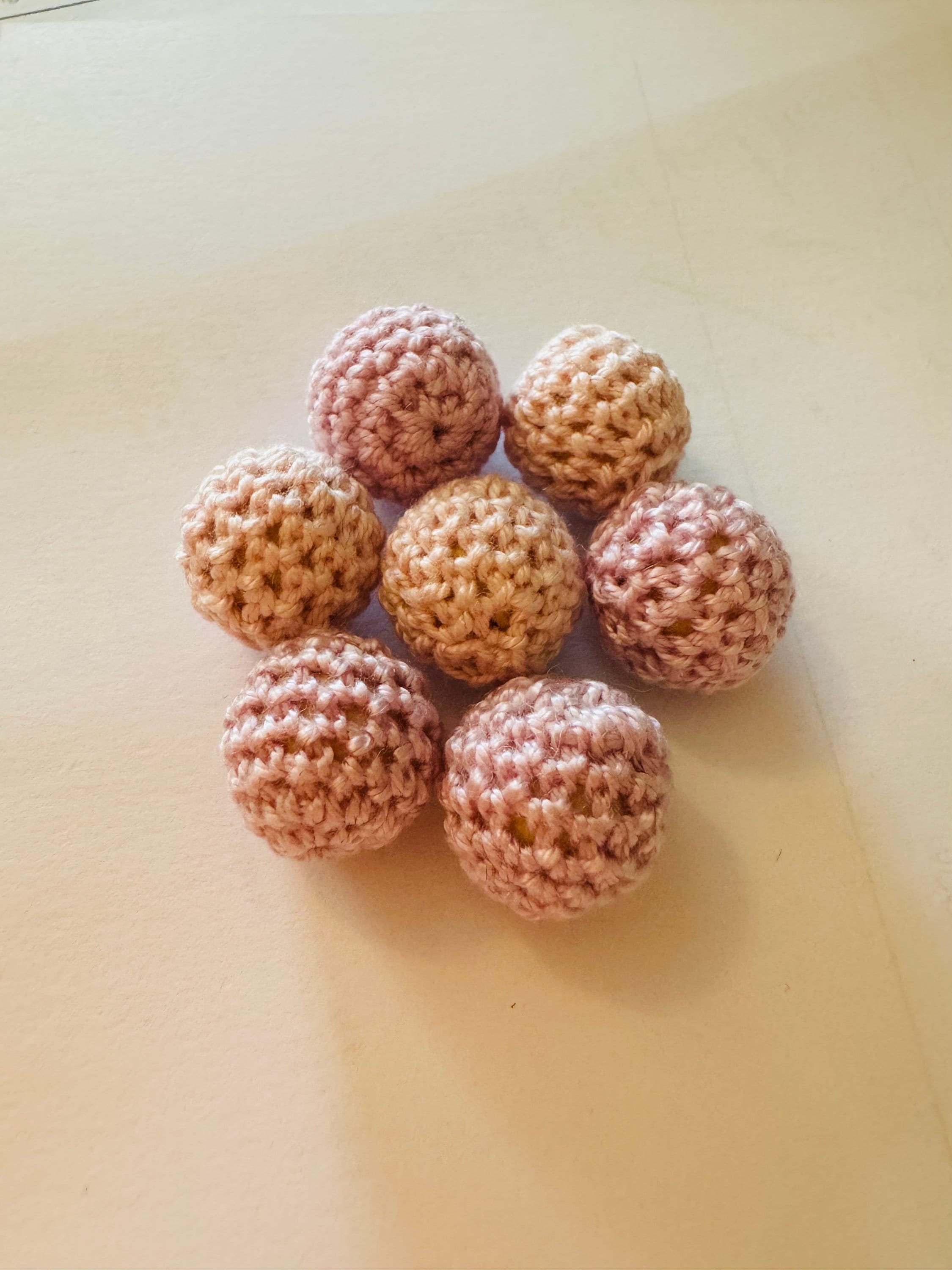 Crochet beaded wooden balls in warm or cool tones, perfect for sensory play, jewelry-making, or decor.