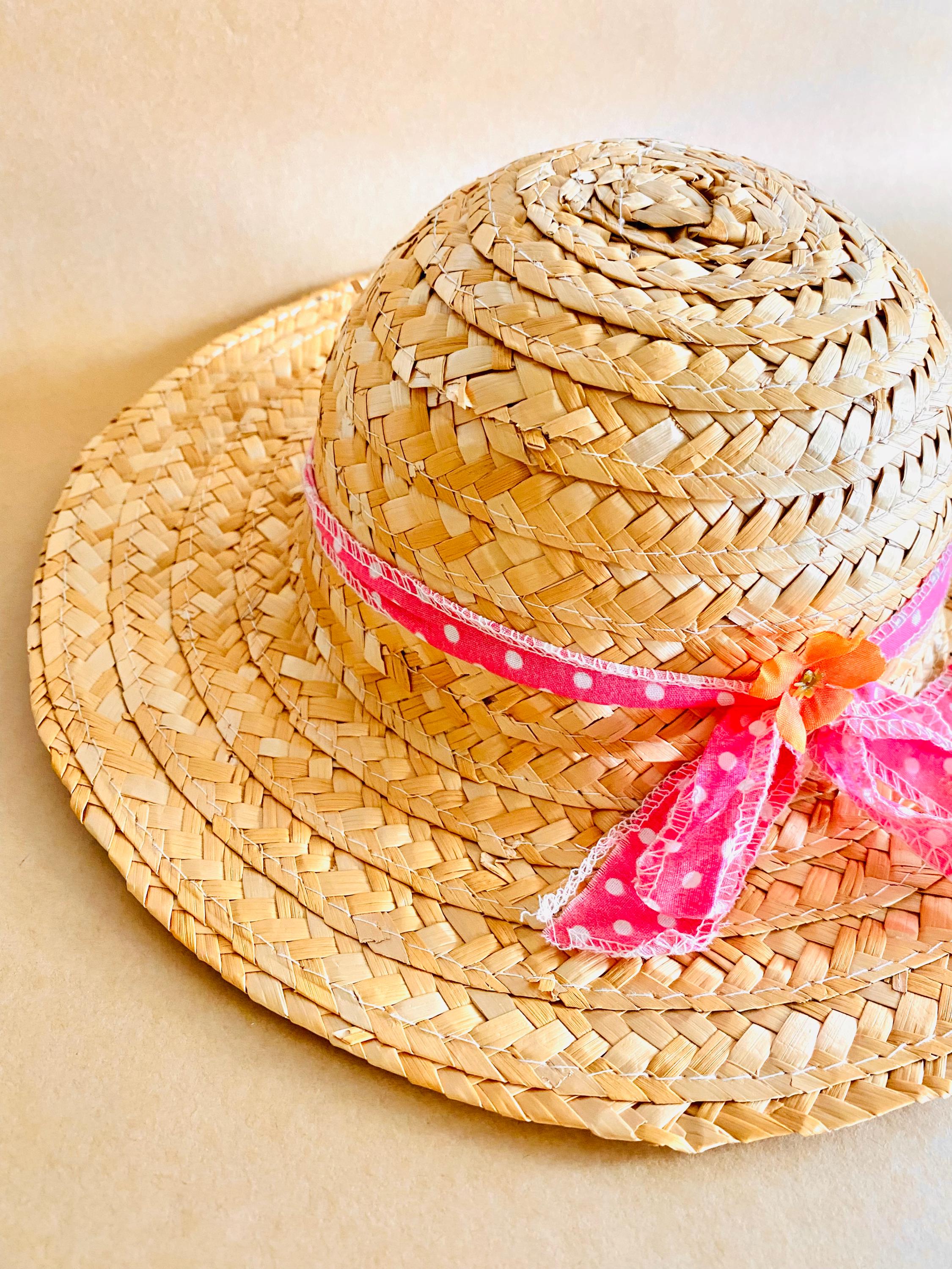 Plain straw hat with a pink ribbon, perfect for doll dress-up or adding rustic charm to decor projects.