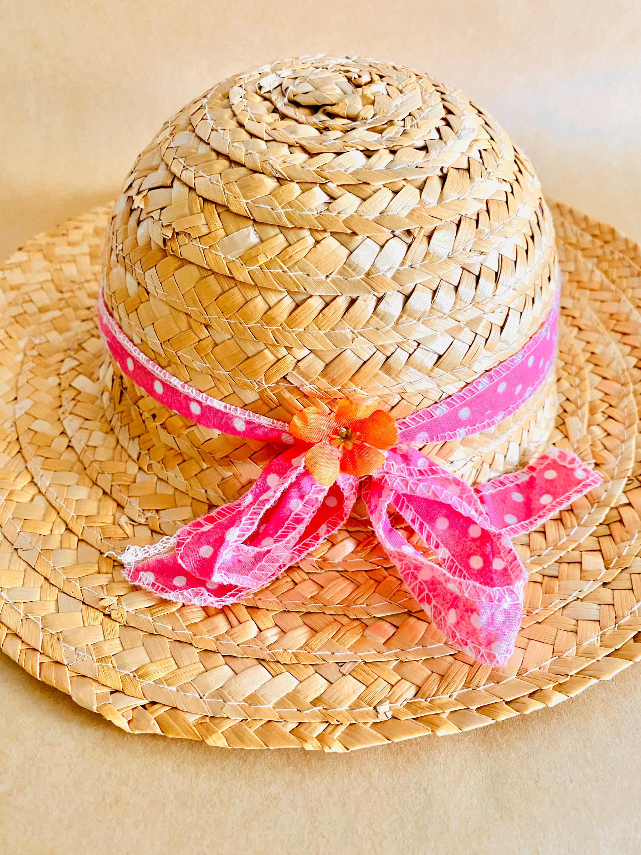 Plain straw hat with a pink ribbon, perfect for doll dress-up or adding rustic charm to decor projects.