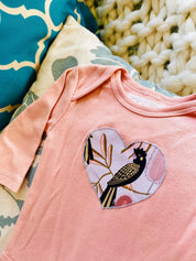 Peach Black Cockatoo Onesie: 100% cotton onesie featuring a peach black cockatoo design, handmade in Western Australia.