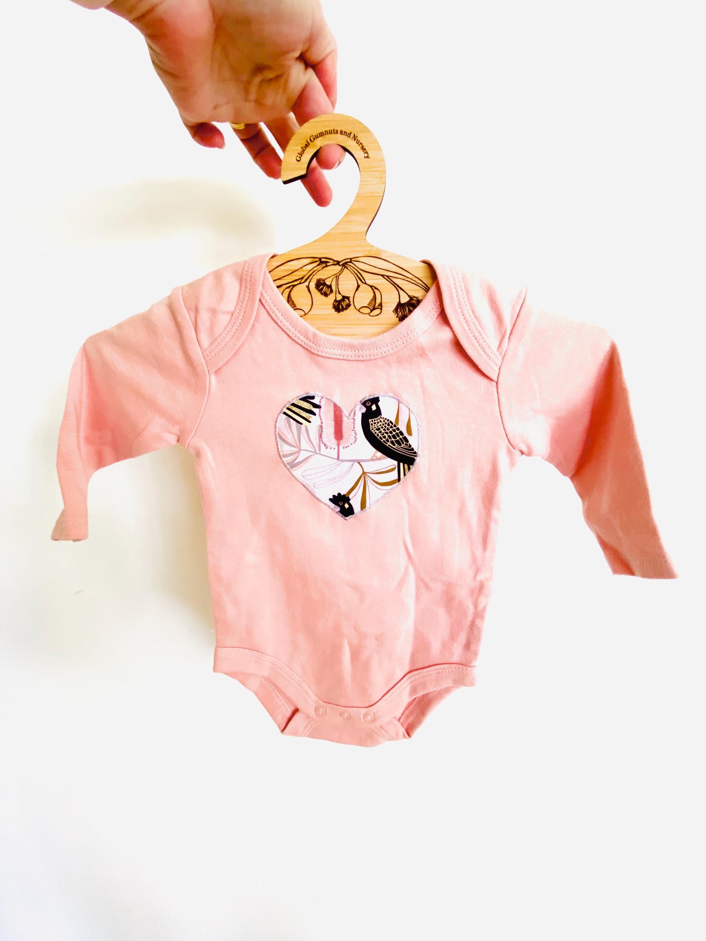 Peach Black Cockatoo Onesie: 100% cotton onesie featuring a peach black cockatoo design, handmade in Western Australia.