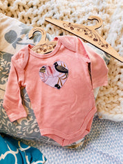 peach black cockatoo onesie: 100% cotton onesie featuring a peach black cockatoo design, handmade in western australia.