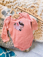 Peach Black Cockatoo Onesie: 100% cotton onesie featuring a peach black cockatoo design, handmade in Western Australia.