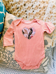 Peach Black Cockatoo Onesie: 100% cotton onesie featuring a peach black cockatoo design, handmade in Western Australia.