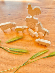 Unpainted birchwood farm animal set, an 8-piece Montessori toy perfect for creative play and crafting.