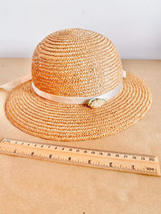 Straw hat with ribbon and floral accents, perfect for crafting, wall decor, or doll dress-up.