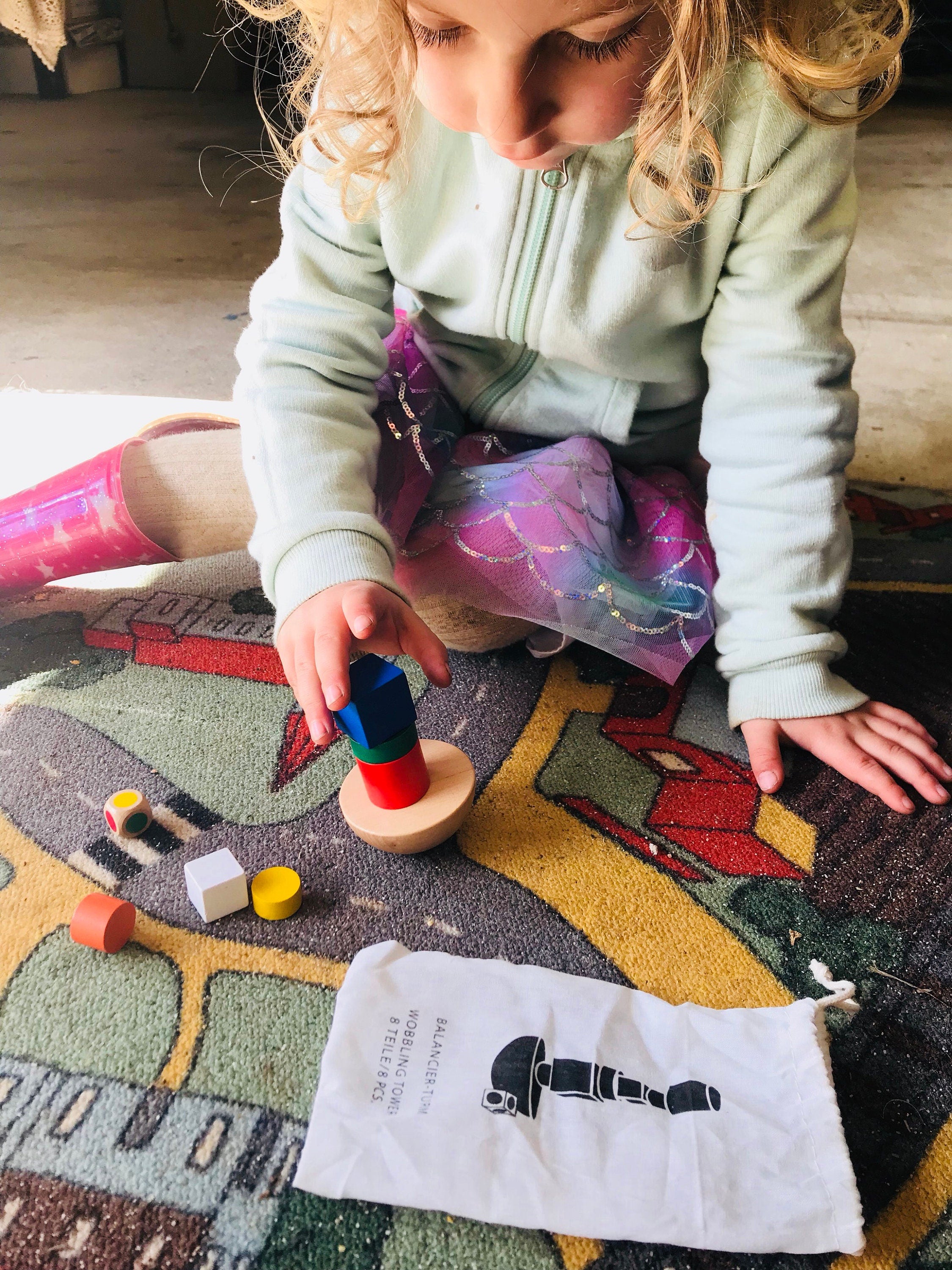 Colorful 8-piece wooden geometric block balancing game. Perfect for improving motor skills and encouraging STEM learning through play.