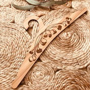 Wooden coat hanger featuring gumnuts and eucalyptus designs, bringing a touch of Australian nature to your closet.