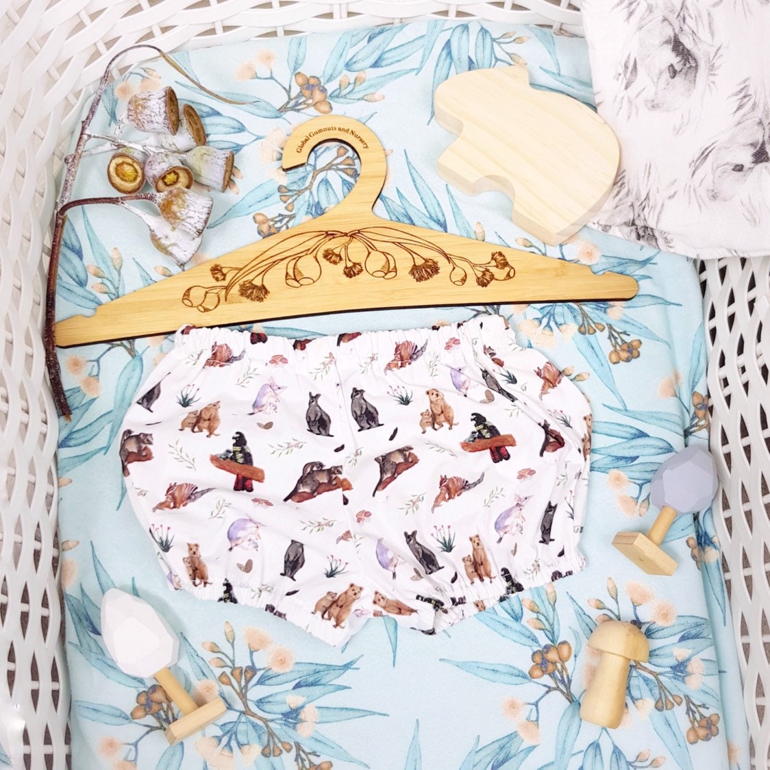 Wooden coat hanger featuring gumnuts and eucalyptus designs, bringing a touch of Australian nature to your closet.
