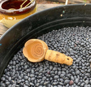 Water play scoop with holes in a bucket, perfect for sensory or outdoor play.
