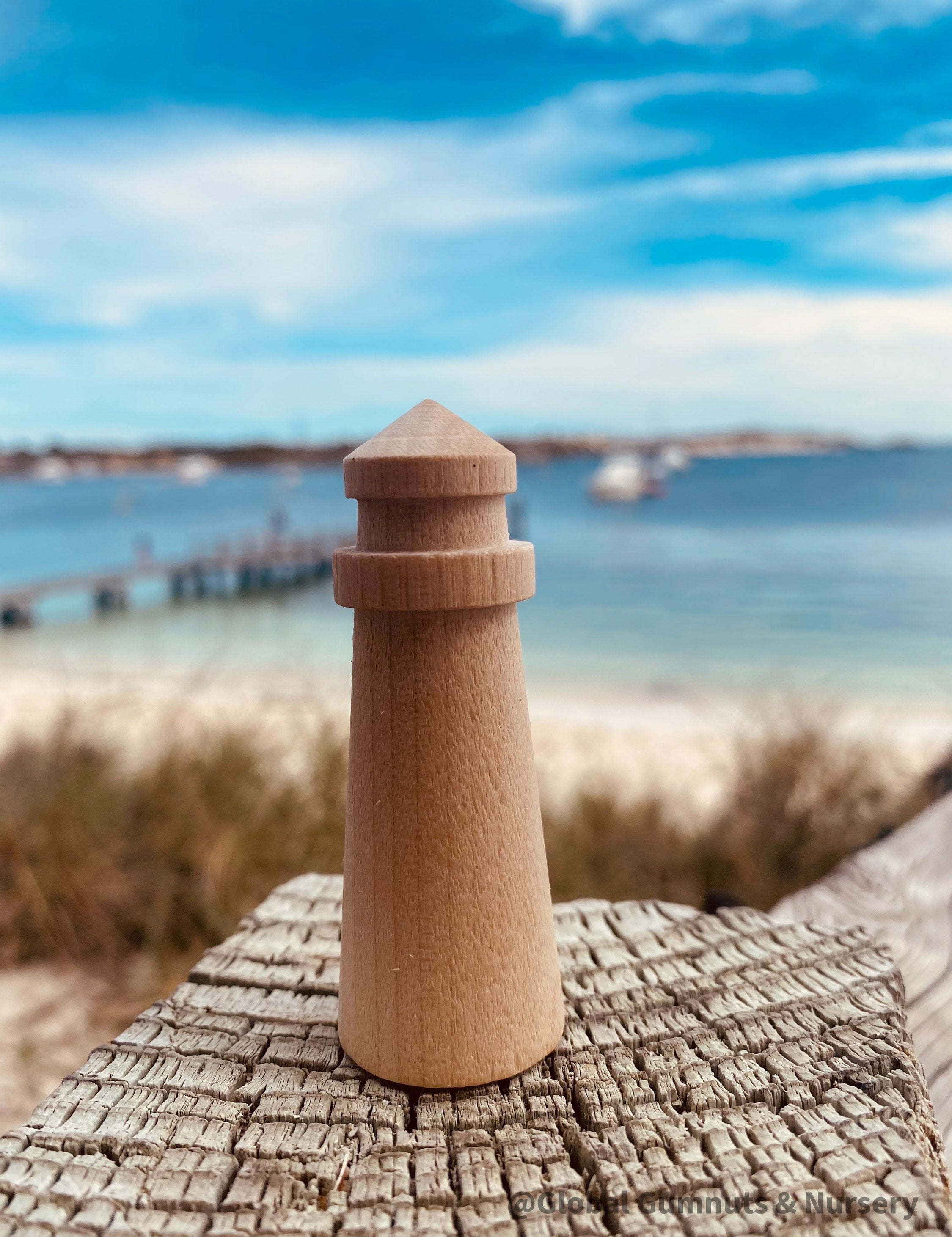 Mini wooden lighthouse, a charming addition to beach-themed decor or playtime.
