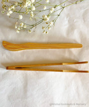 Wooden Toddler Tongs: Curved wooden tongs designed for toddlers' motor skill development.