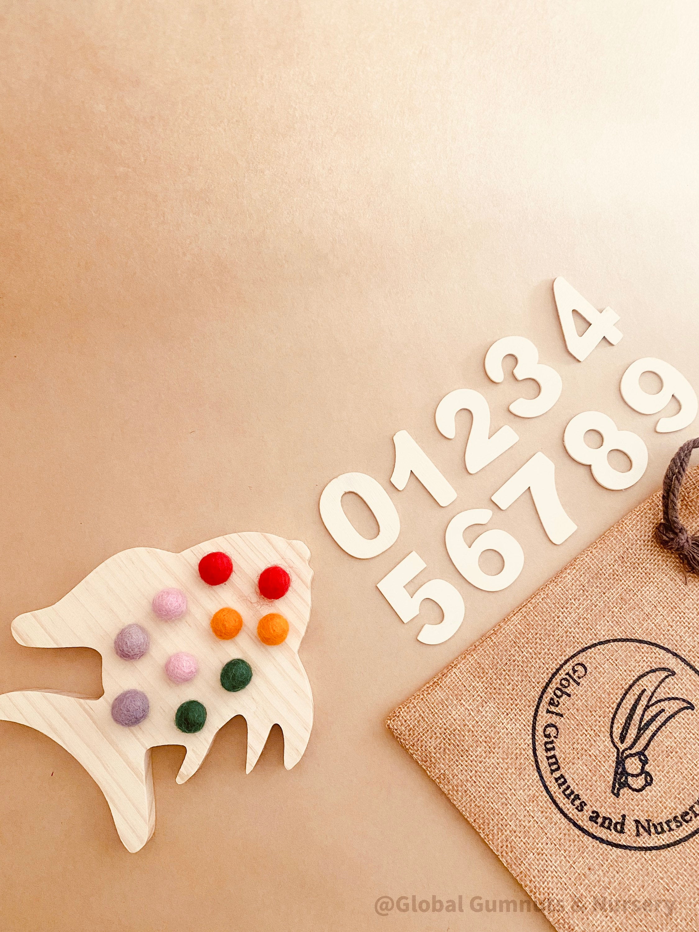 rainbow fish tens board: montessori-style tens board featuring colourful felt balls and wooden numbers, designed for teaching counting and early math skills.