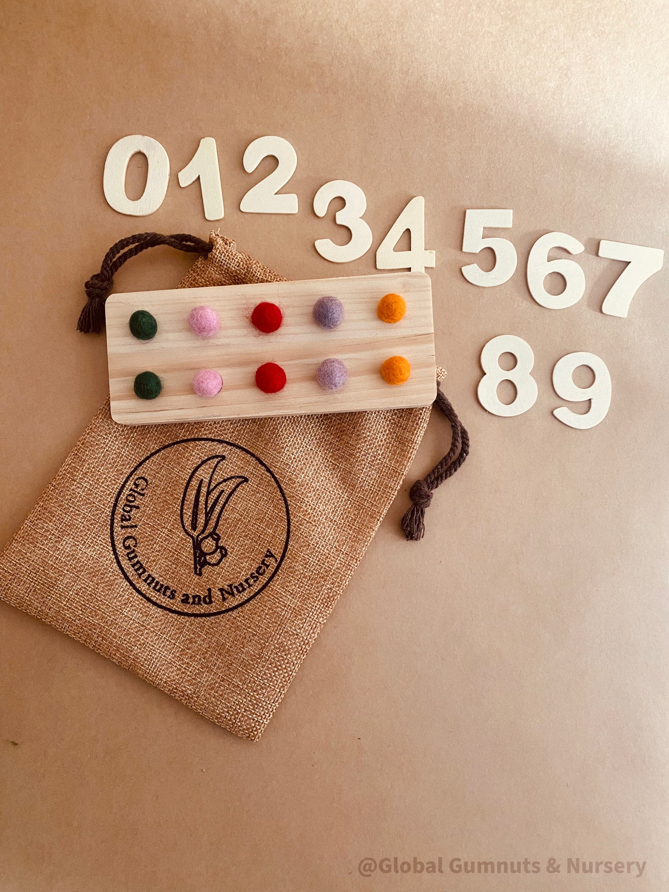 tens board with felt balls and numbers: educational toy with mini felt balls and wooden numbers, made from 100% nz wool, for play-based counting activities.
