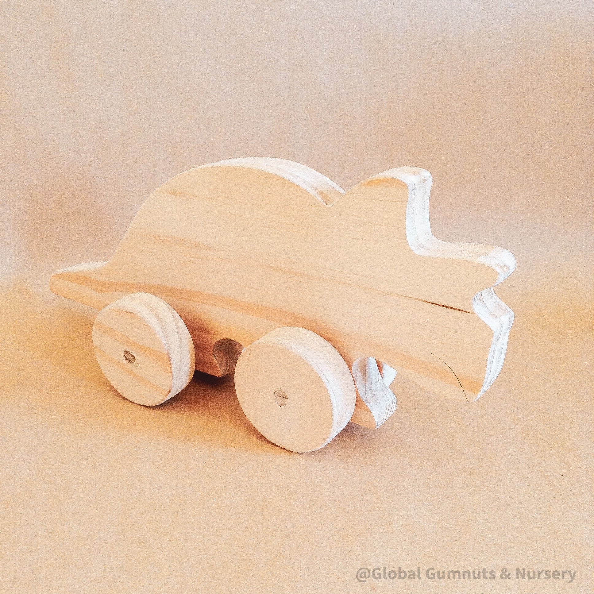 Wooden Dinosaur Push Pull Toy: Handmade wooden dinosaur on wheels for imaginative play.