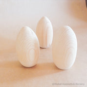 Flat-bottomed wooden egg, ideal for Easter crafts, displays, or creative projects.
