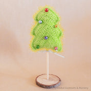 Crochet Christmas tree adorned with colorful bells. A cheerful, handmade addition to holiday decor.