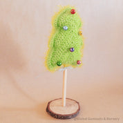 Crochet Christmas tree adorned with colorful bells. A cheerful, handmade addition to holiday decor.