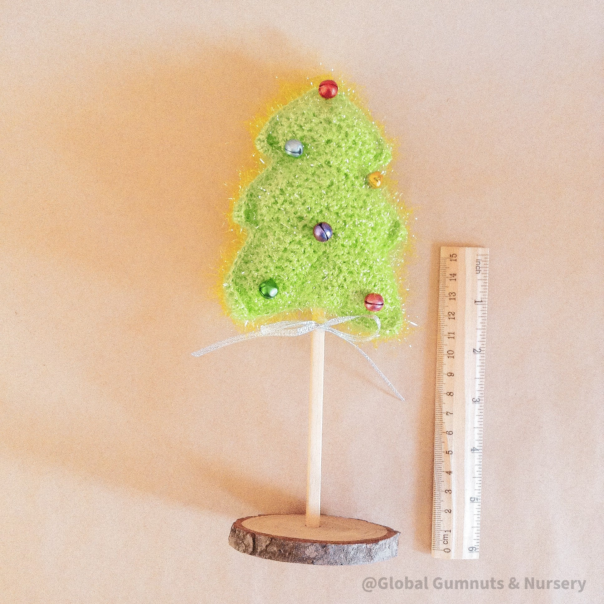 Crochet Christmas tree adorned with colorful bells. A cheerful, handmade addition to holiday decor.