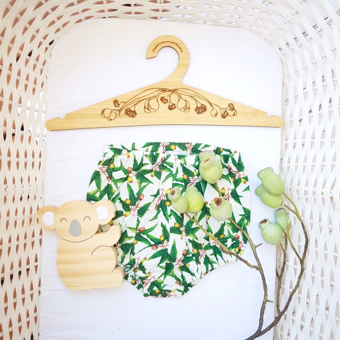 Wooden coat hanger featuring gumnuts and eucalyptus designs, bringing a touch of Australian nature to your closet.