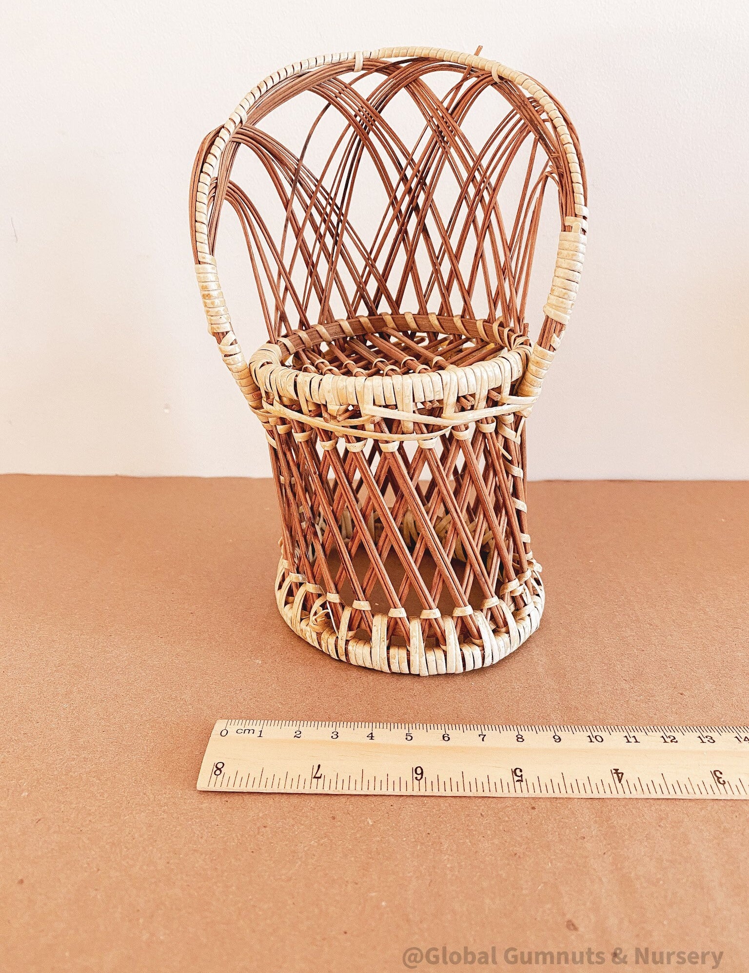 Vintage wicker doll's chair, measuring 20cm x 10cm.
