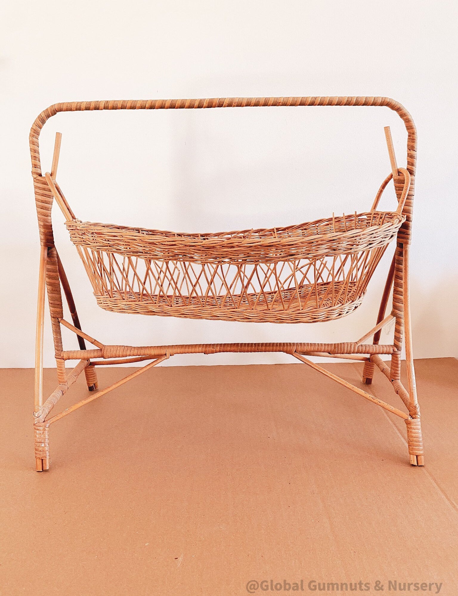 Vintage dolls rocking cot, a two-piece wicker delight.
