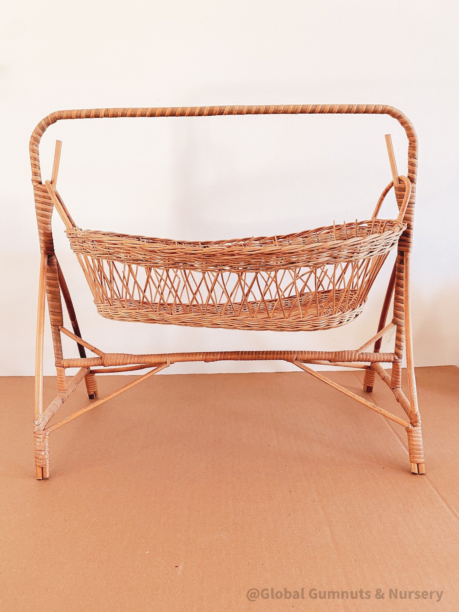 Vintage dolls rocking cot, a two-piece wicker delight.
