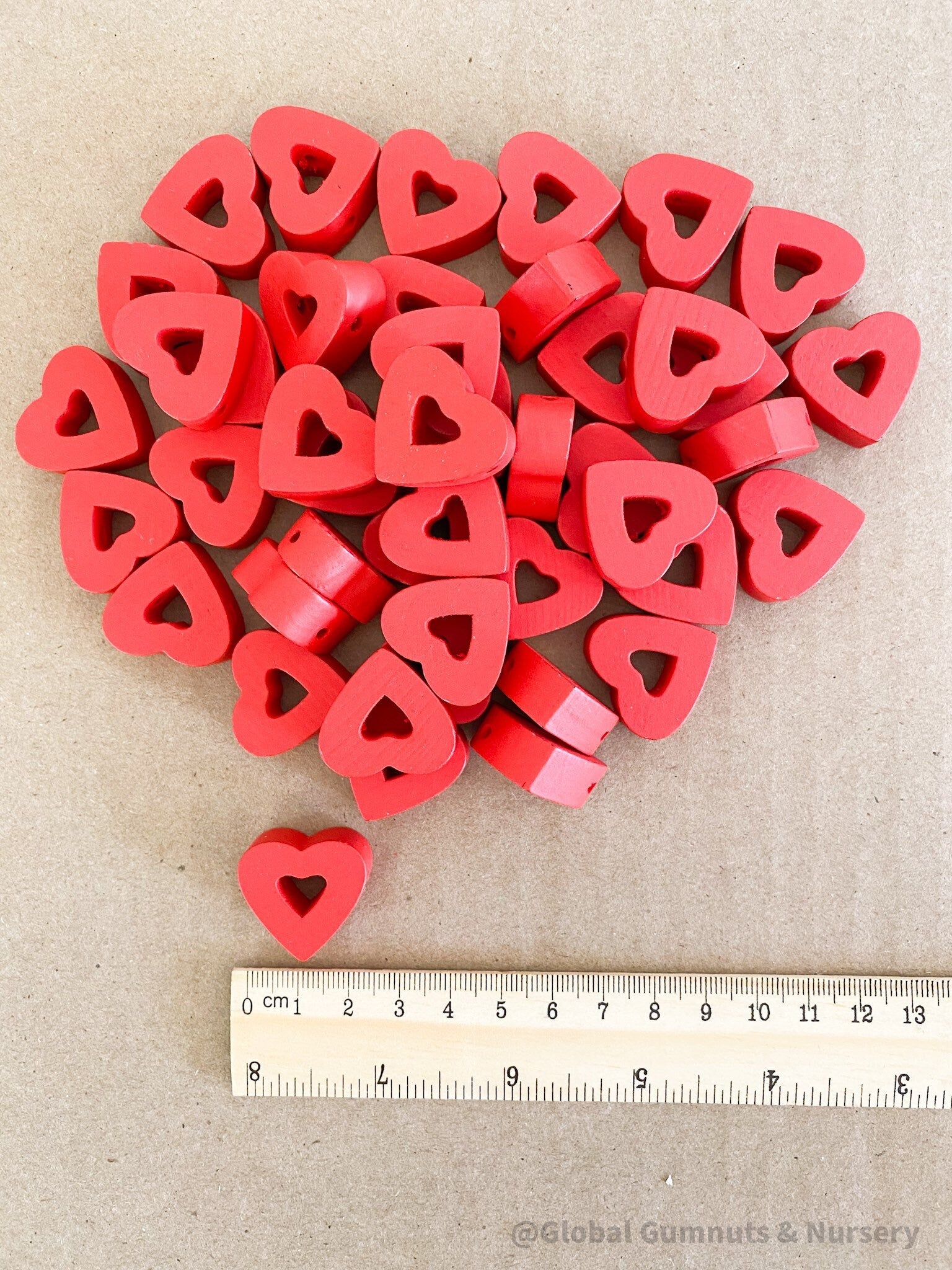 Whimsical red wooden heart beads, ideal for Valentine's Day crafts and projects.