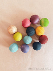 Vibrant dyed wooden balls for crafting and learning, set of 12 in a tan or pink bag.

