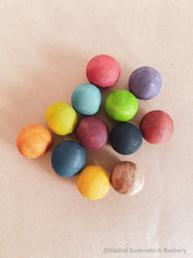 Vibrant dyed wooden balls for crafting and learning, set of 12 in a tan or pink bag.
