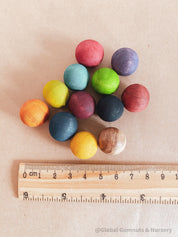 Vibrant dyed wooden balls for crafting and learning, set of 12 in a tan or pink bag.
