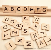 26-piece wooden uppercase letter tiles, ideal for teaching letter recognition, Scrabble, and creative craft projects.