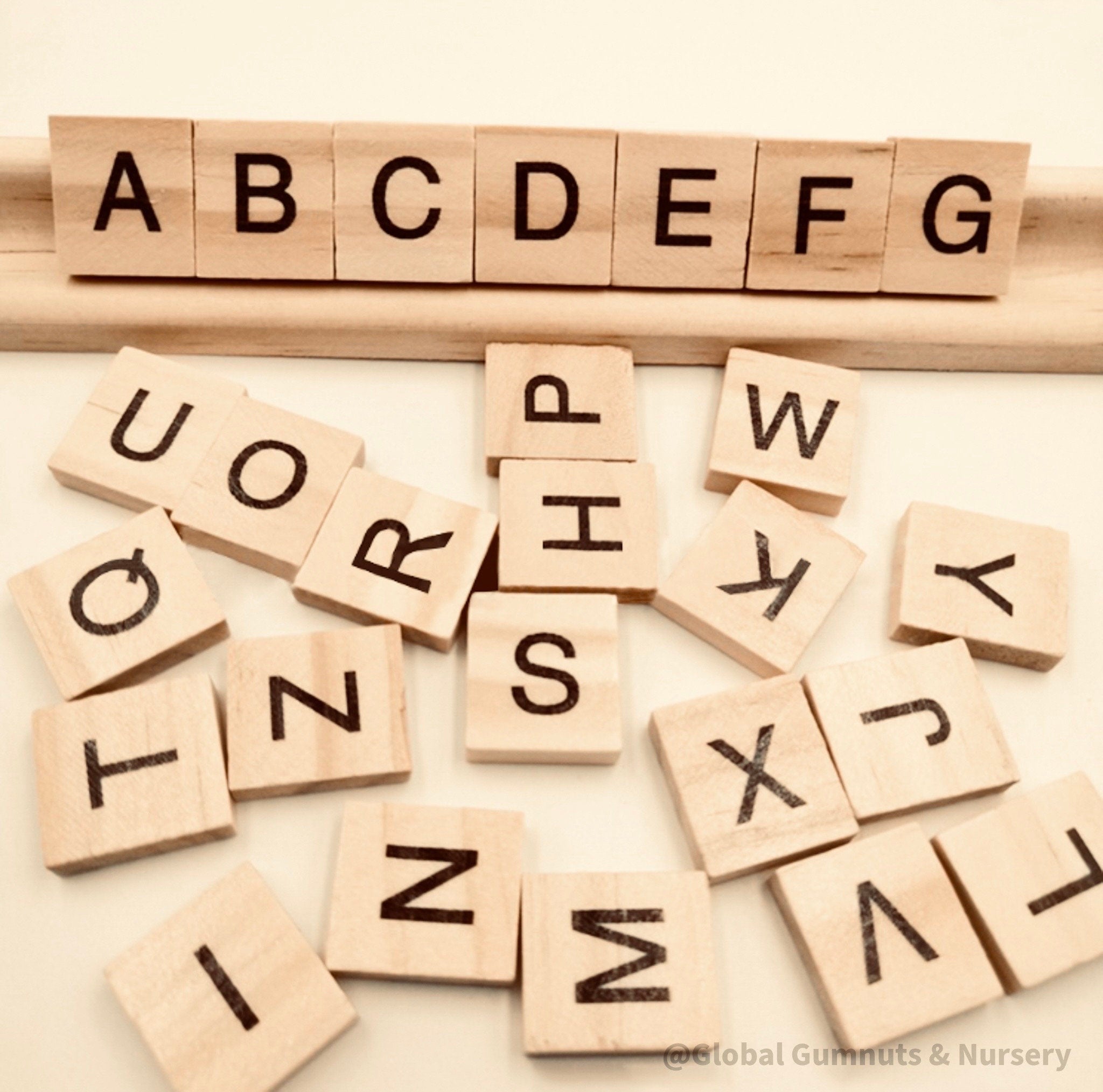 26-piece wooden uppercase letter tiles, ideal for teaching letter recognition, Scrabble, and creative craft projects.