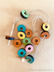 Rainbow Threading Beads: Colourful wooden beads for threading and sensory play, designed to encourage fine motor skills and creativity.